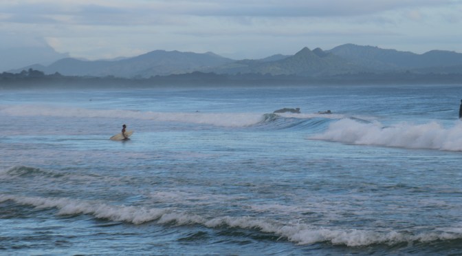 A lone surfer enters the water at Byron Bay in Australia.