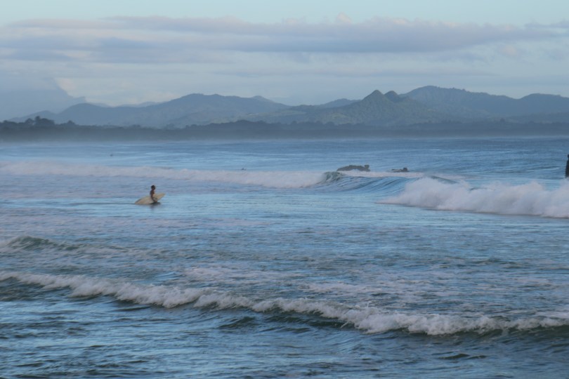 A lone surfer enters the water at Byron Bay in Australia.