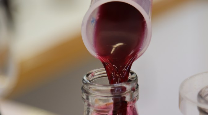 Pouring red wine in the lab at Ata Rangi in New Zealand.