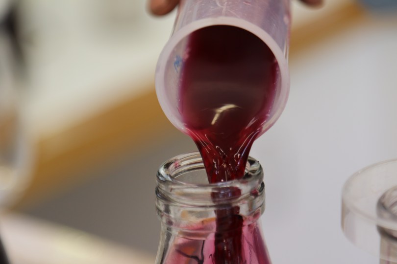 Pouring red wine in the lab at Ata Rangi in New Zealand.